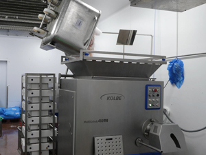 ingredients for sausage with ice being loaded into mixer