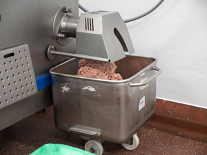 mixed sausage meat emerging from the mixer
